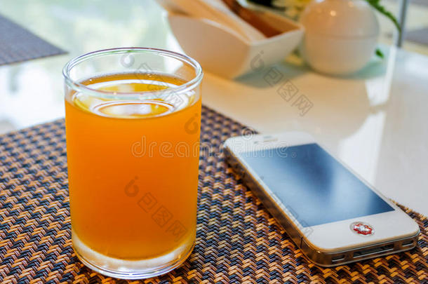 一杯带手机的橙汁。