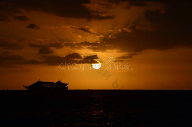 夕阳西下的夜空衬托出游轮的轮廓