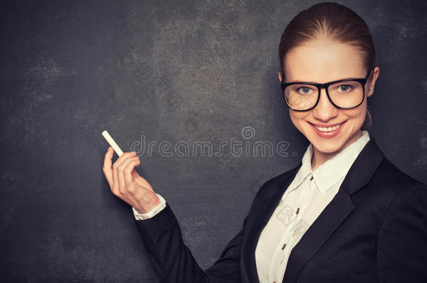 一位戴着眼镜和一套带着粉笔的<strong>西服</strong>的商务女教师