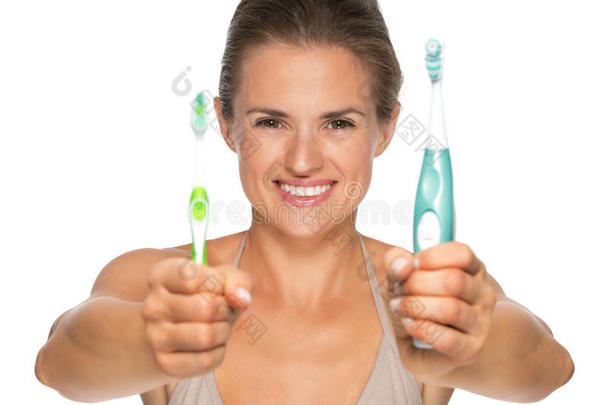 快乐的女人在展示旧的电动牙刷
