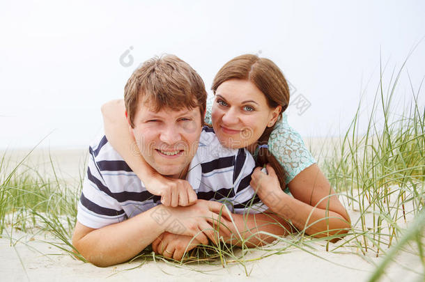 年轻幸福的恋爱情侣在沙滩上嬉戏