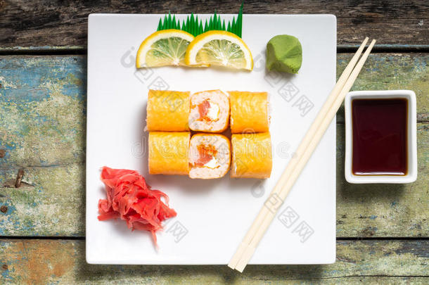 传统的费城寿司卷放在白色盘子里，有筷子和芥末