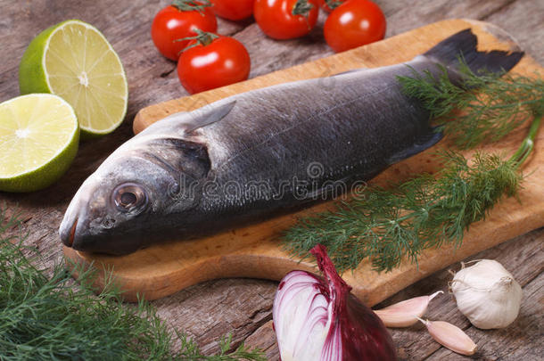 新鲜的生鱼片鲈鱼和蔬菜一起放在砧板上