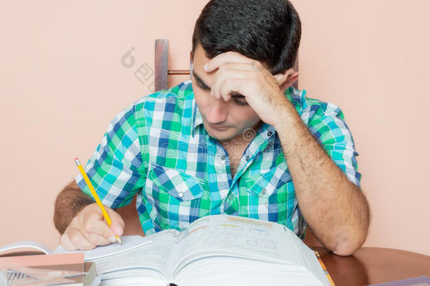 成年西班牙裔男子在笔记本上学习和写作