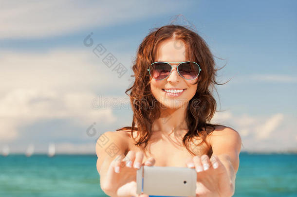 快乐微笑的女人用手机摄像头