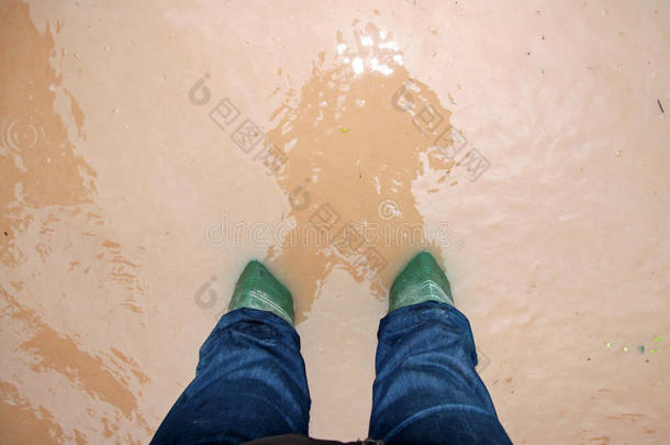 在城市的洪水中，绿色的救援人员靴子