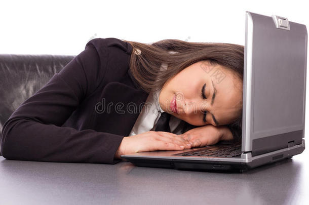 <strong>劳累</strong>过度的女商人睡在笔记本电脑上精疲力竭