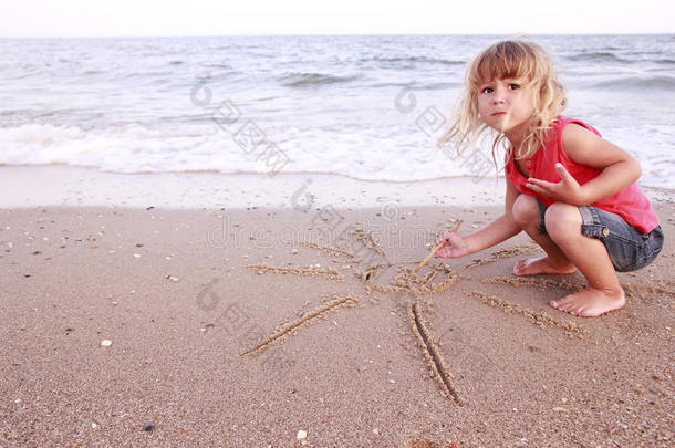 小女孩在海边的沙滩上晒太阳