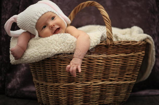 篮子里穿着兔子服装的微笑宝宝
