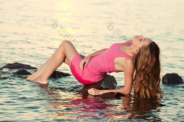 日落时海滩上的美女。享受大自然。奢华女孩r
