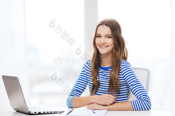 微笑的少女笔记本电脑和笔记本