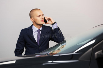 年轻的商人在车外打电话图片