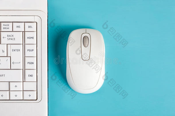 桌上有白色<strong>鼠标</strong>和<strong>笔记本</strong>电脑键盘。