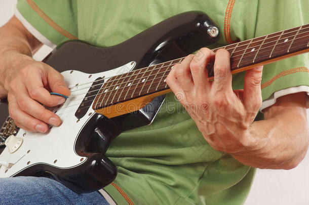 吉他手把手指放在电吉他上的和弦特写