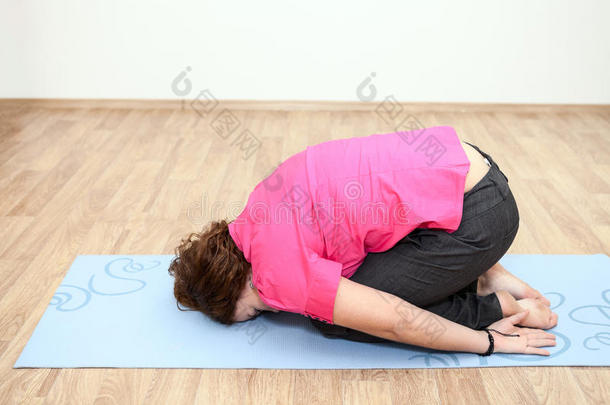 年轻女子躺在垫子上做瑜伽姿势
