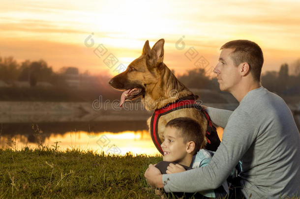 父子俩和德国牧羊犬在大自然中观看日落