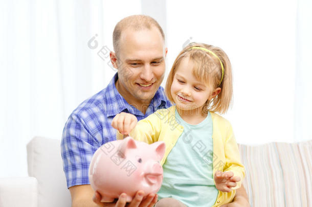 快乐的爸爸和女儿带着大存钱罐