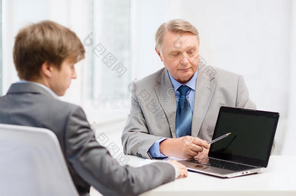 老人和年轻人拿着笔记本电脑