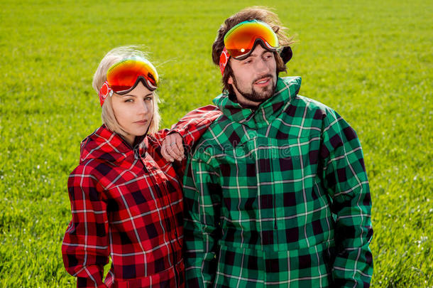 一对穿着滑雪服戴着太阳眼镜的夫妇和s并肩站在一起