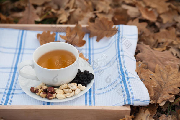一杯茶和一盘榛子放在餐巾纸上