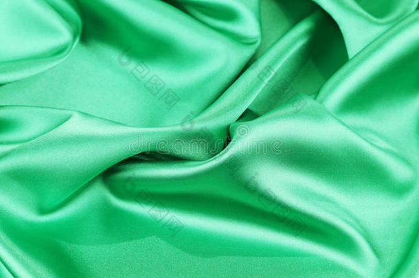 绿色丝绸背景柔和的褶皱和亮点。