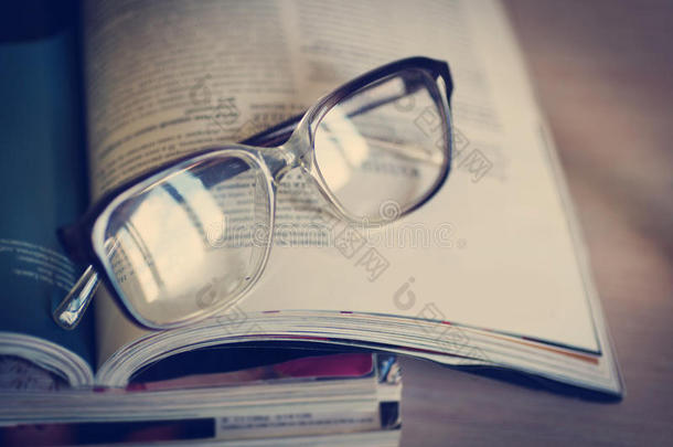 在一堆杂志上阅读的眼镜，软聚焦