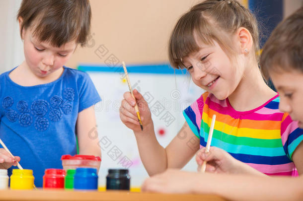 幼儿园里可爱的小朋友用五颜六色的颜料画画