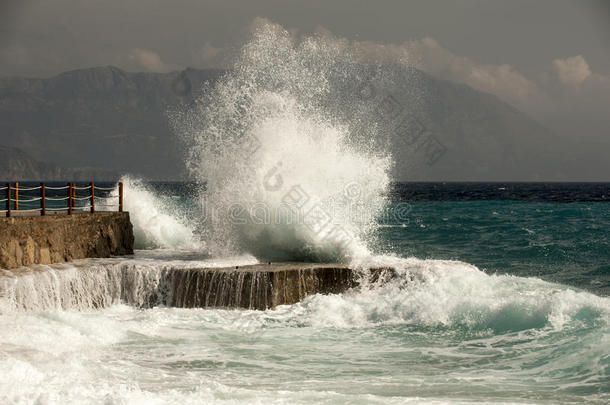 波浪在多石的海滩上破碎，形成一股浪花