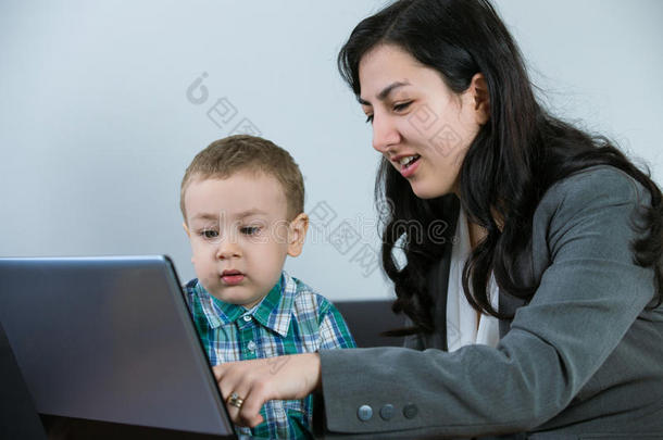 妈妈在电脑屏幕上给她的儿子看东西