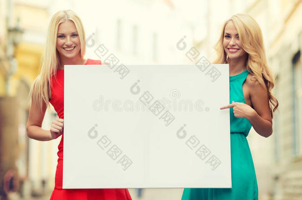 两个快乐的金发女人拿着空白的白板
