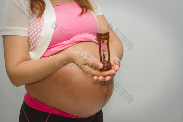 孕妇拿着一个<strong>沙漏计时器</strong>