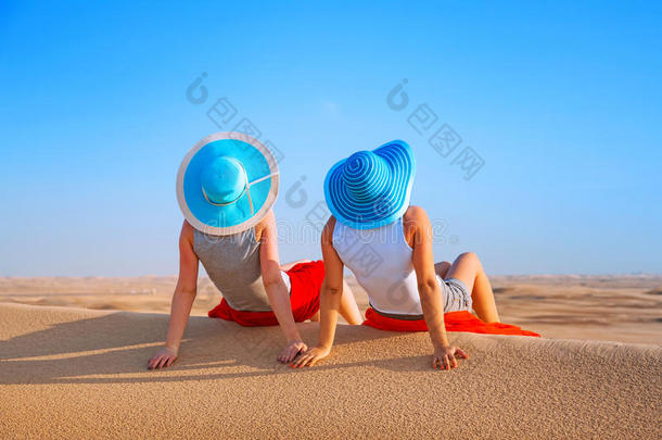 两个戴着帽子<strong>的</strong>女孩在<strong>沙漠里</strong>放松