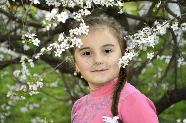春天花园里有一个小女孩拿着樱桃枝。