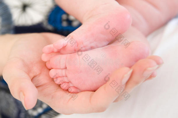 新生儿母亲的手在婴儿的脚
