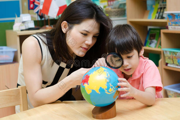 学生在听老师<strong>讲课</strong>时看着地球