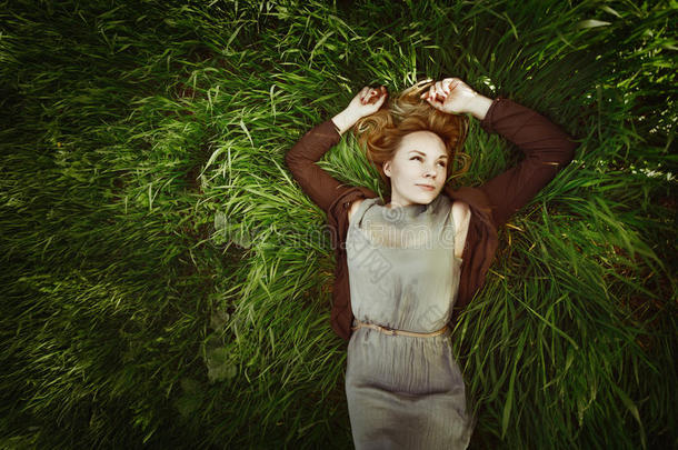 美丽的年轻女子躺在草地上。<strong>复古色</strong>彩。夏天，