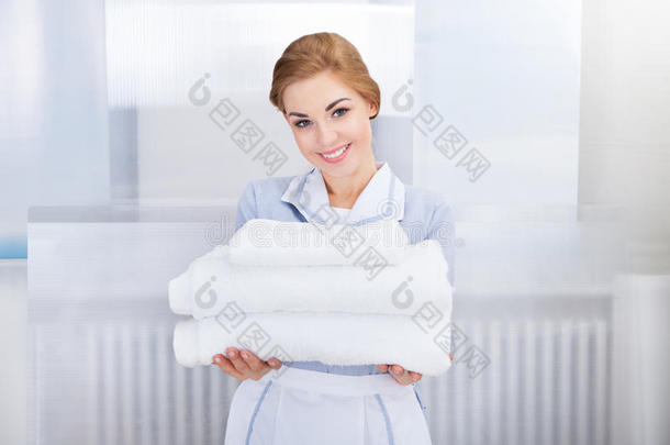 拿着一堆毛巾的女佣