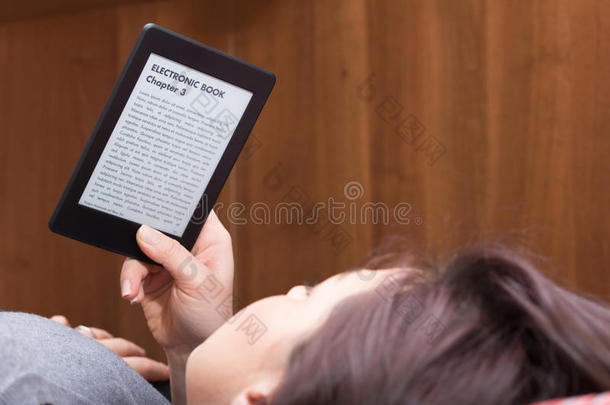 女孩在床上用<strong>电子</strong>书阅读器看书