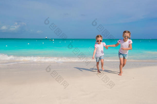 <strong>小女孩</strong>们沿着白色的海滩<strong>奔跑</strong>，玩得很开心