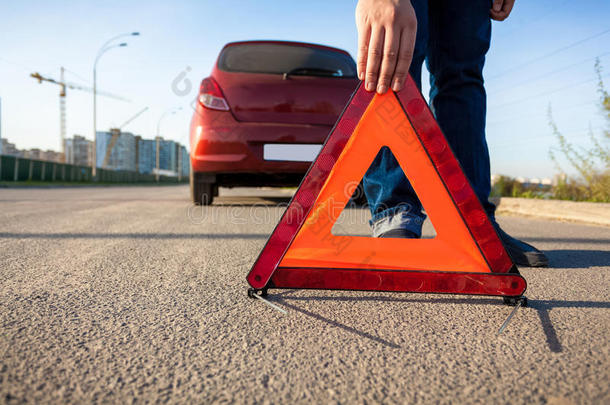 男子在道路上放置三角<strong>警示牌</strong>的照片