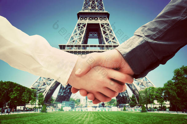 在法国巴黎做生意。埃菲尔铁塔背景握手