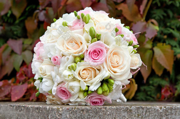 一束白色，粉色，奶油色的玫瑰作为婚礼的礼物。