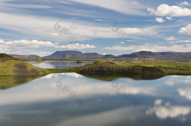 冰岛米瓦顿湖，覆盖着草的火山口在静水中反射