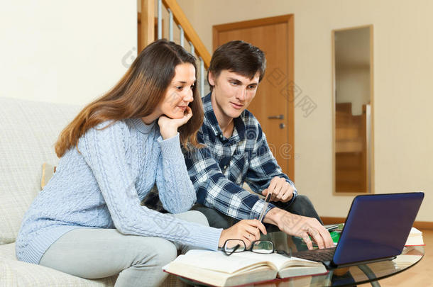 认真的男生女生拿着笔记本电脑备考