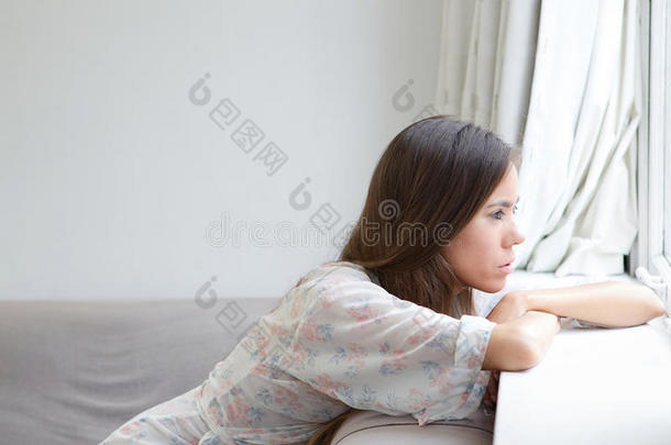 一个年轻的女人独自坐着<strong>看窗外</strong>