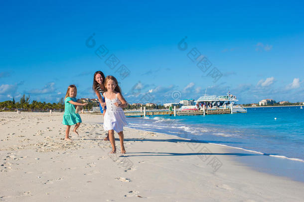 阳光明媚的日子里，年轻快乐的母亲和她可<strong>爱</strong>的女儿们在异<strong>国风</strong>情的海滩上嬉戏