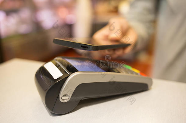 在超市里，用nfc技术在手机上付钱的女人