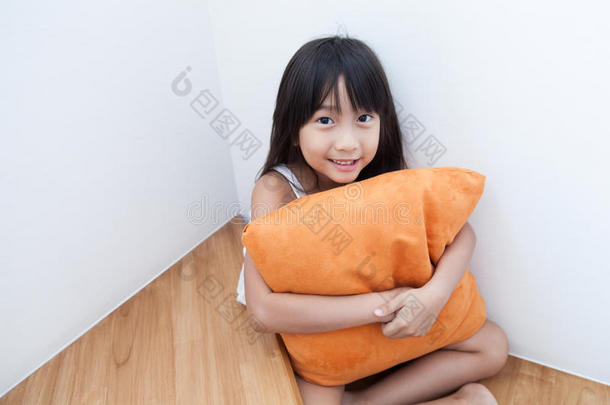 女孩坐在抱枕橙色。
