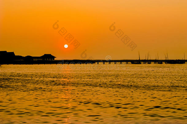 夕阳下码头和大海的剪影。