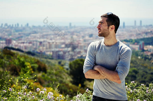 美丽的年轻徒步旅行者站在山丘上眺望远方，大城市背景